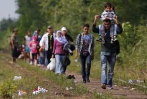Syrian immigrants walk on a railway track after they crossed the Hungarian-Serbian border near Roszke